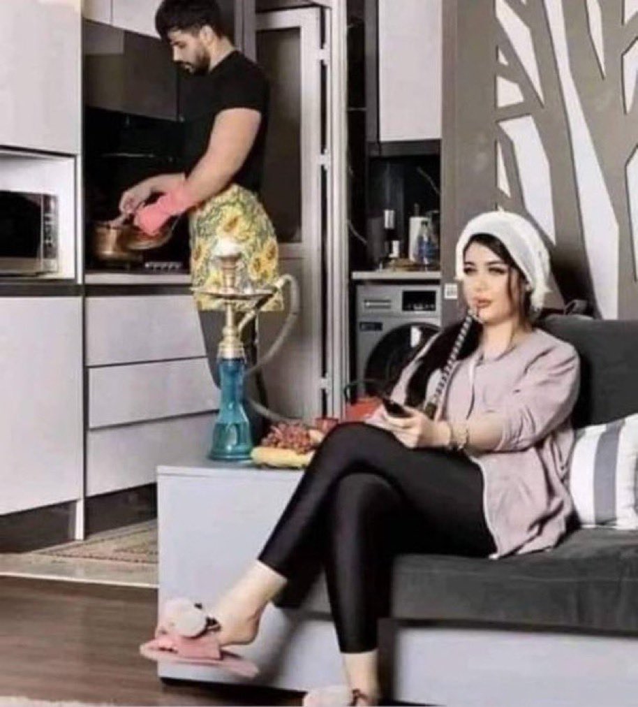 Homme cuisinant pendant que sa femme fume une chiha Égalité des sexes en action