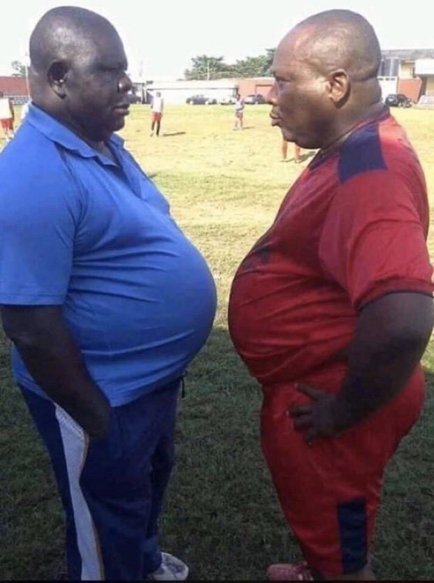 Deux hommes obèses se tiennent face à face sur un terrain de sport Bleu vs Rouge