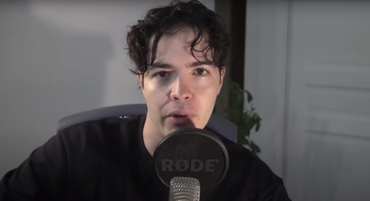 TGR The Great Review Augustin Jeune homme sérieux parlant face caméra avec micro – ambiance YouTube ou podcast, ton analytique et posé