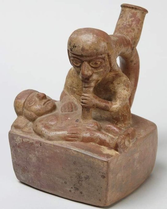 Statue maya avec figure assise sucant une bite
