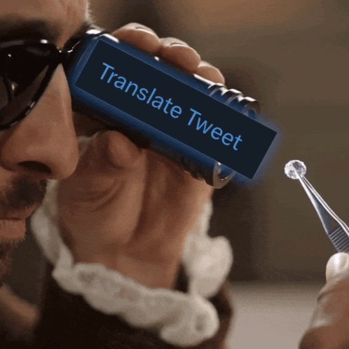 Un homme observe un petit diamant avec un loupe Translate Tweet