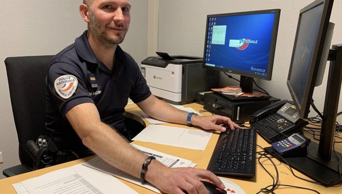 Un policier national tape sur son ordinateur au bureau