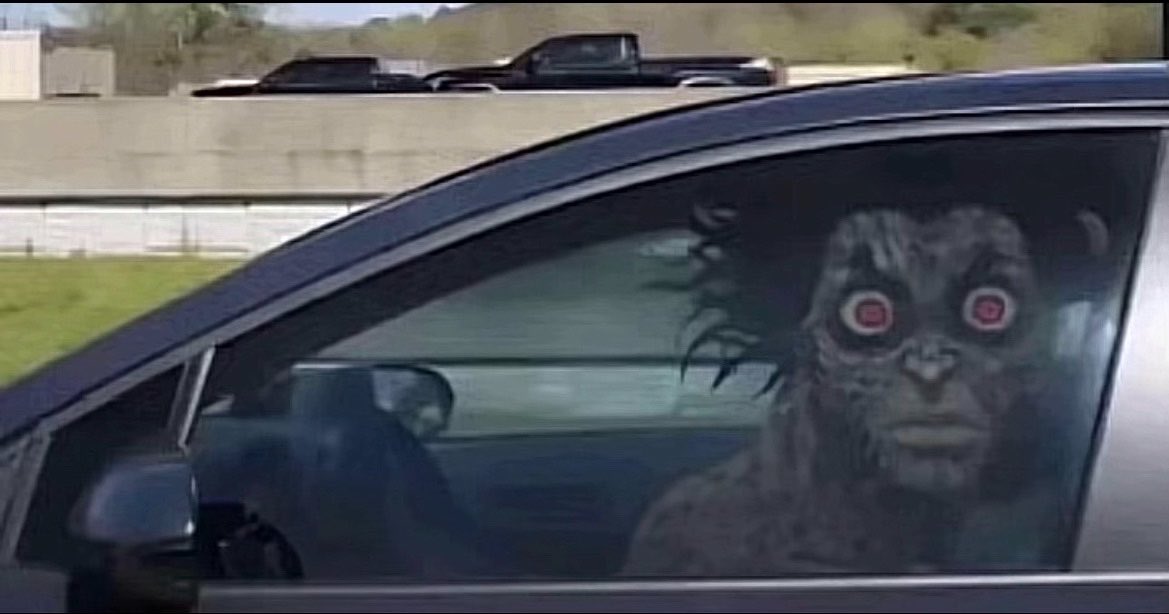 Une créature effrayante conduit une voiture sur l'autoroute