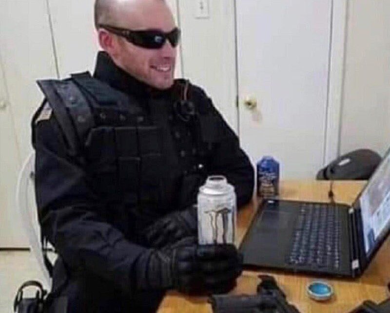 Un flic/policier/gendarme boit une Monster devant son ordinateur