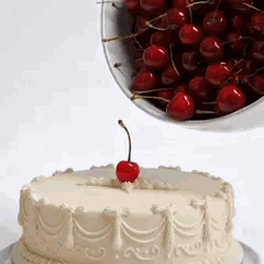 Verser un bol entier de cerises sur un gâteau déjà décoré