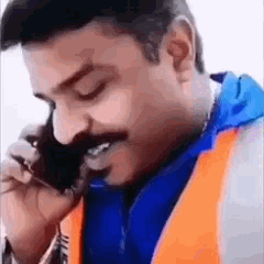 Un homme indien au telephone indiquant de se taire de manière menaçante