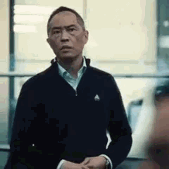 Un homme asiatique fronce les sourcils avec un air dubitatif et refuse/réfute
