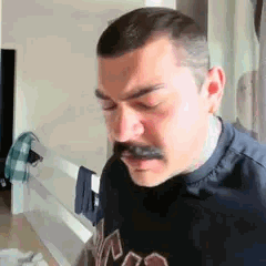 Un homme a moustaches s'arrête puis regard l'interlocuteur de manière intrigué
