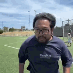 Un homme asiatique court sur un terrain de sport