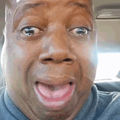 Un homme pleure de choc avec une grimace exagérée dans sa voiture
