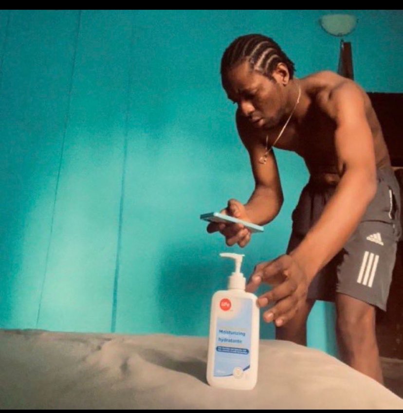 Un homme torse nu s'apprête à se masturber/branler avec un flacon de crème hydratante