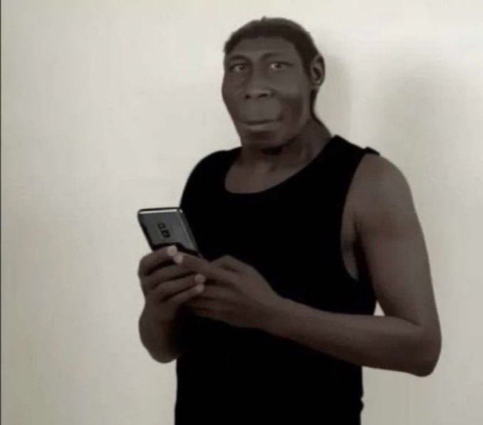 Homme préhistorique/singe en débardeur tenant un smartphone