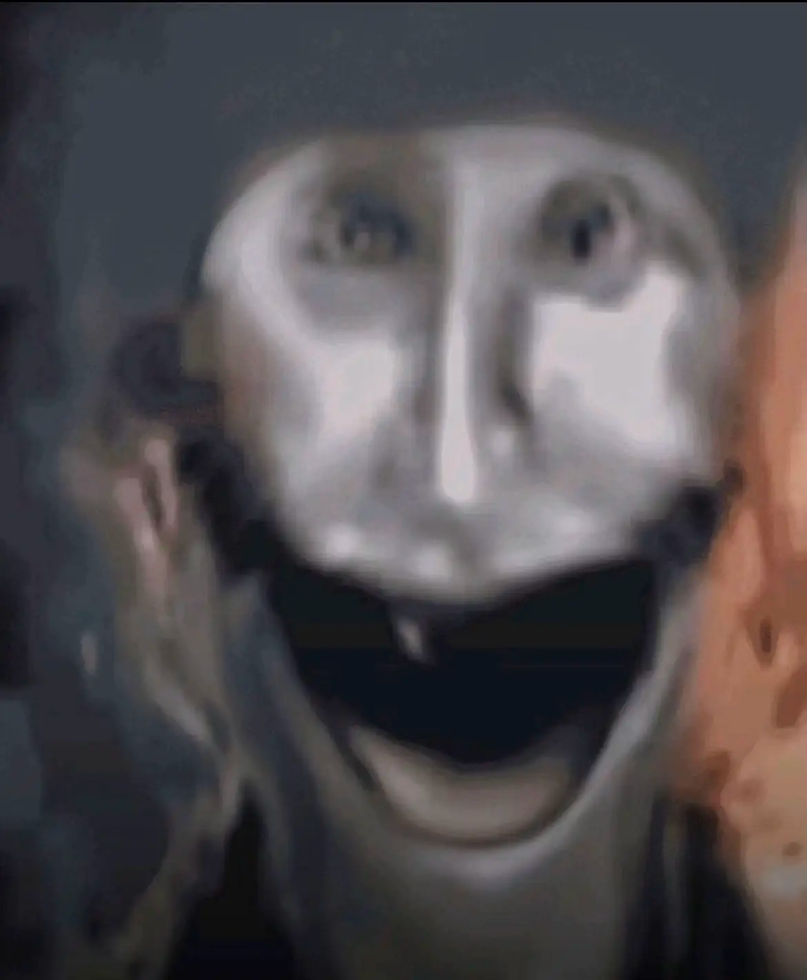 Visage déformé souriant de manière effrayante et débile