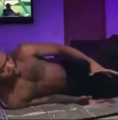 Un homme torse nu baise de manière imaginaire sur son lit