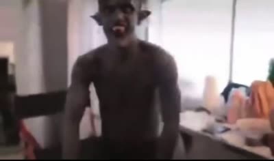 Un homme maquillé en démon danse de manière festive