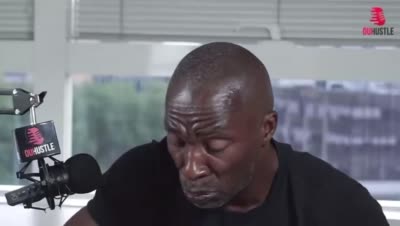 MC Jean Gab'1 boit dans une tasse puis lève la tête d'un air sceptique