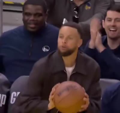 Stephen Curry qui tente un tir à trois points depuis le banc mais abandonne