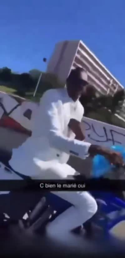 snapchat - c bien le marié oui. Un marié en costume blanc fait des roues arrière en moto cross