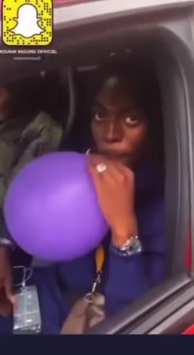 Koba La D inhale un ballon de gaz hilarant dans une voiture pendant que l'interlocuteur lui parle mais il s'en fou et se tire/barre/part