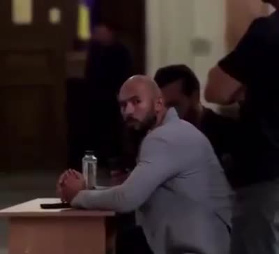 Andrew Tate assis au tribunal et lache un regard dans son dos rapidement