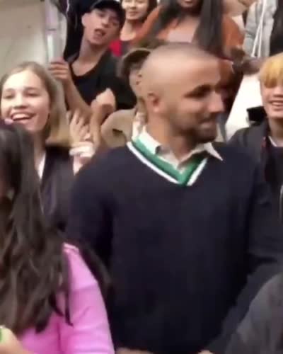 Un jeune homme danse et chante au milieu d'une foule