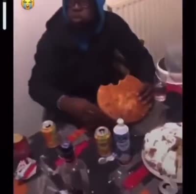 snapchat - Un homme tient un gâteau géant entamé à table à lui tout seul