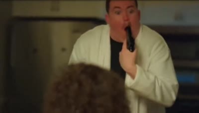 Shane Gillis avec un pistolet dans la bouche puis retire l'arme paniqué et la braque devant lui.