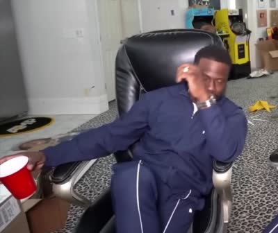 Kevin Hart regarde la caméra puis sourit avec un gobelet