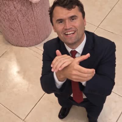 Charlie Kirk applaudit et fait signe de serrer la main de l'interlocuteur