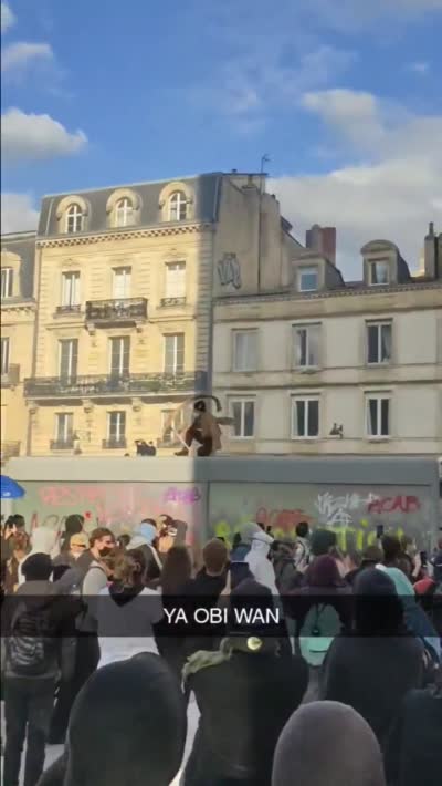 Un homme déguisé en Obi-Wan Kenobi saute sur un abribus en pleine manifestation