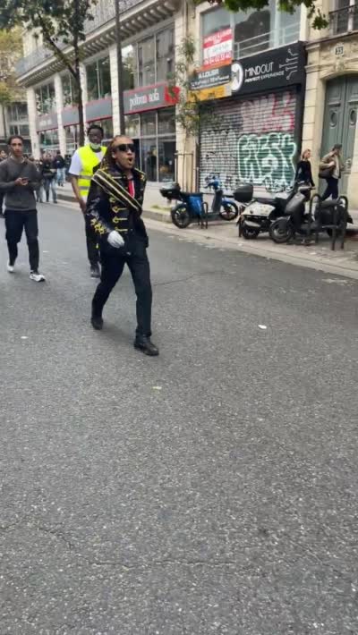 snapchat - 17 octobre 2026, Un homme habillé en Michael Jackson salue la foule dans la rue
