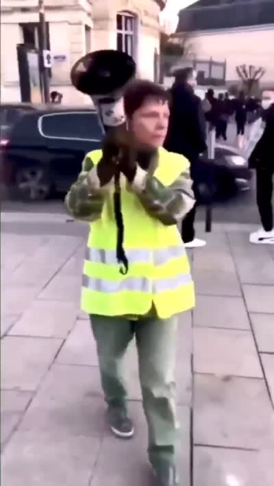 Gilet jaune (Jocelyne Chassard) avec un mégaphone en mode alerte