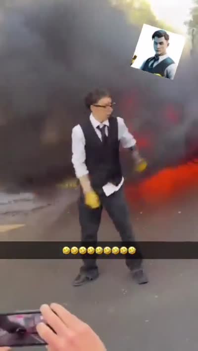 snapchat - Un homme déguisé en Midas danse devant une barricade en feu